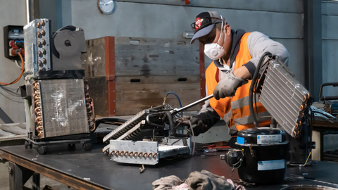 Mitarbeiter bearbeitet das Klimagerät 